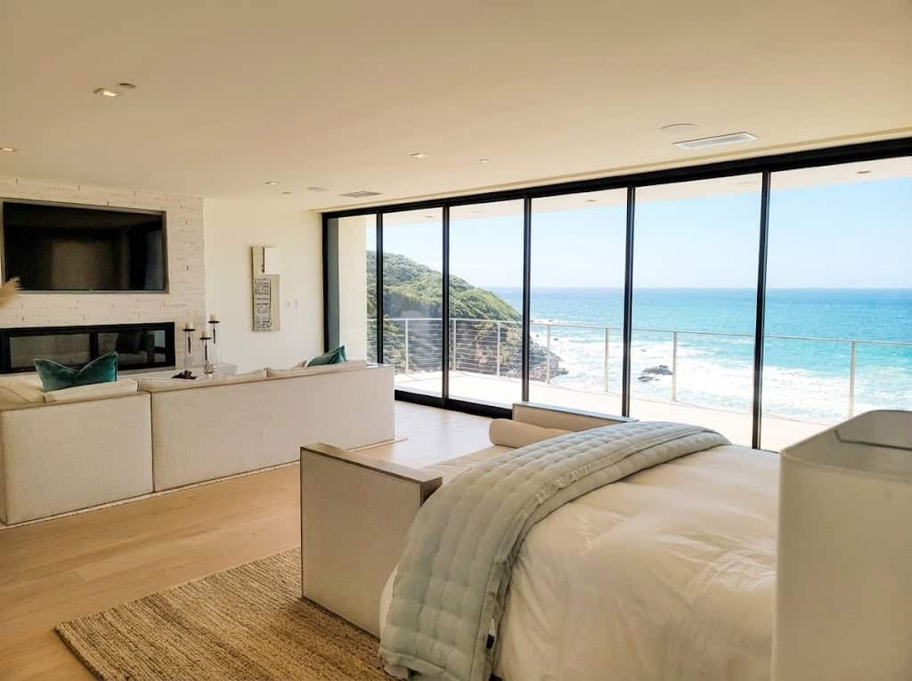 Coastal living room with Monumental 4551 Vari-Slide aluminum sliding glass wall opening to ocean view